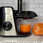 Juicer with Carrot Orange Ginger juice and pulp with the Healthy Mom Healthy Family logo.
