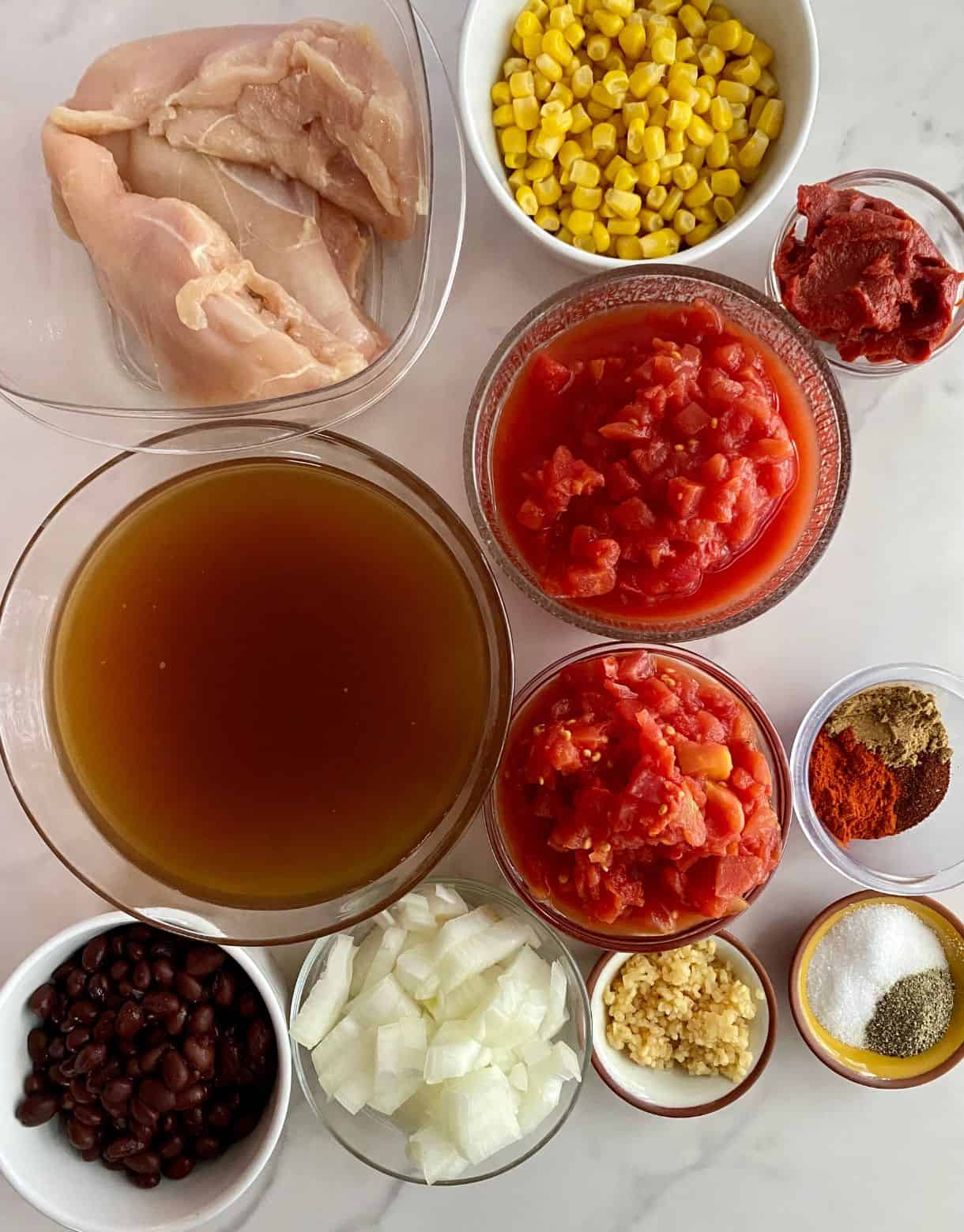Chicken broth, diced tomatoes, corn, black beans, onion, garlic, salt, pepper, spices, tomato paste and raw chicken.