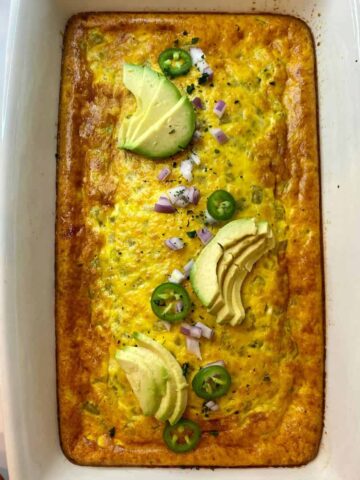 Green Chile Egg Casserole in a pan with sliced avocado on top.