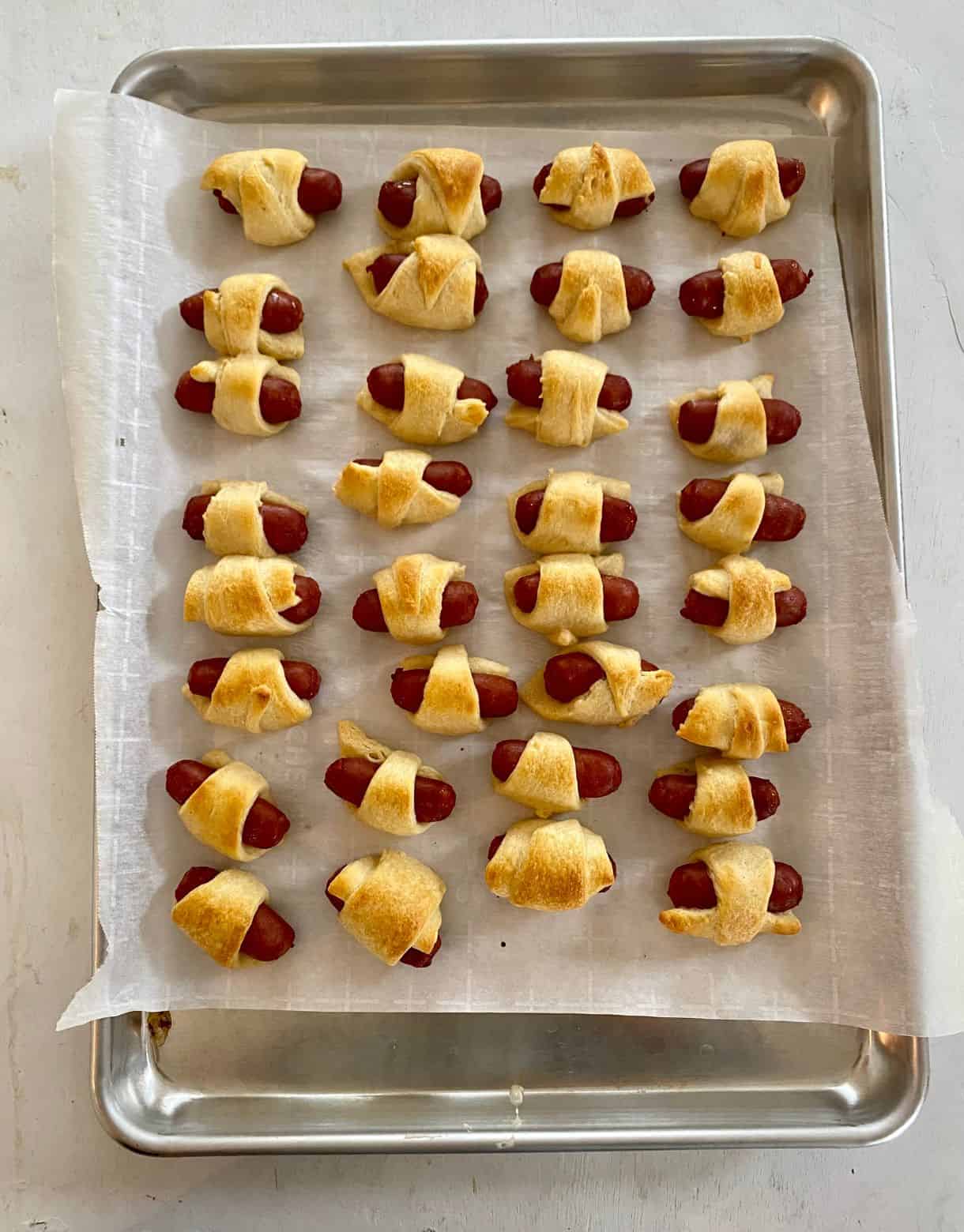 Sheet pan of cooked Pigs in a Blanket.