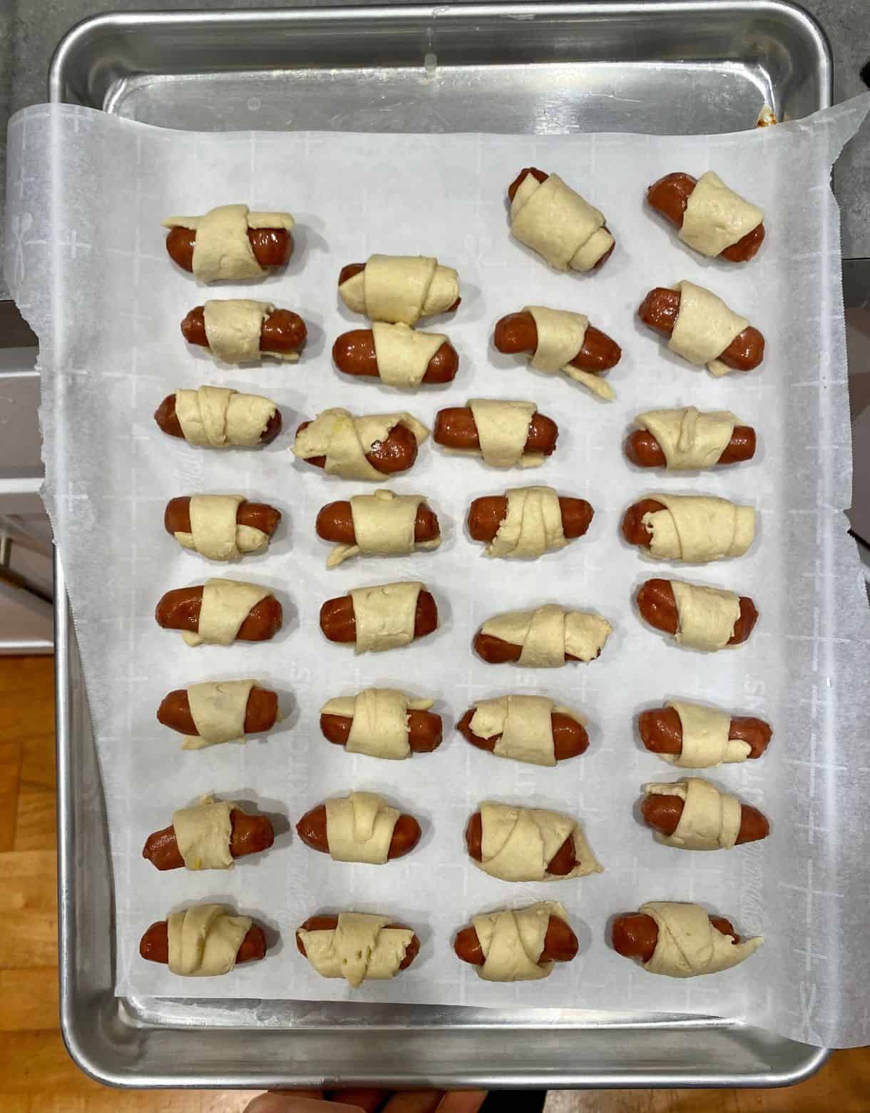 Sheet pan of uncooked Pigs in a Blanket.