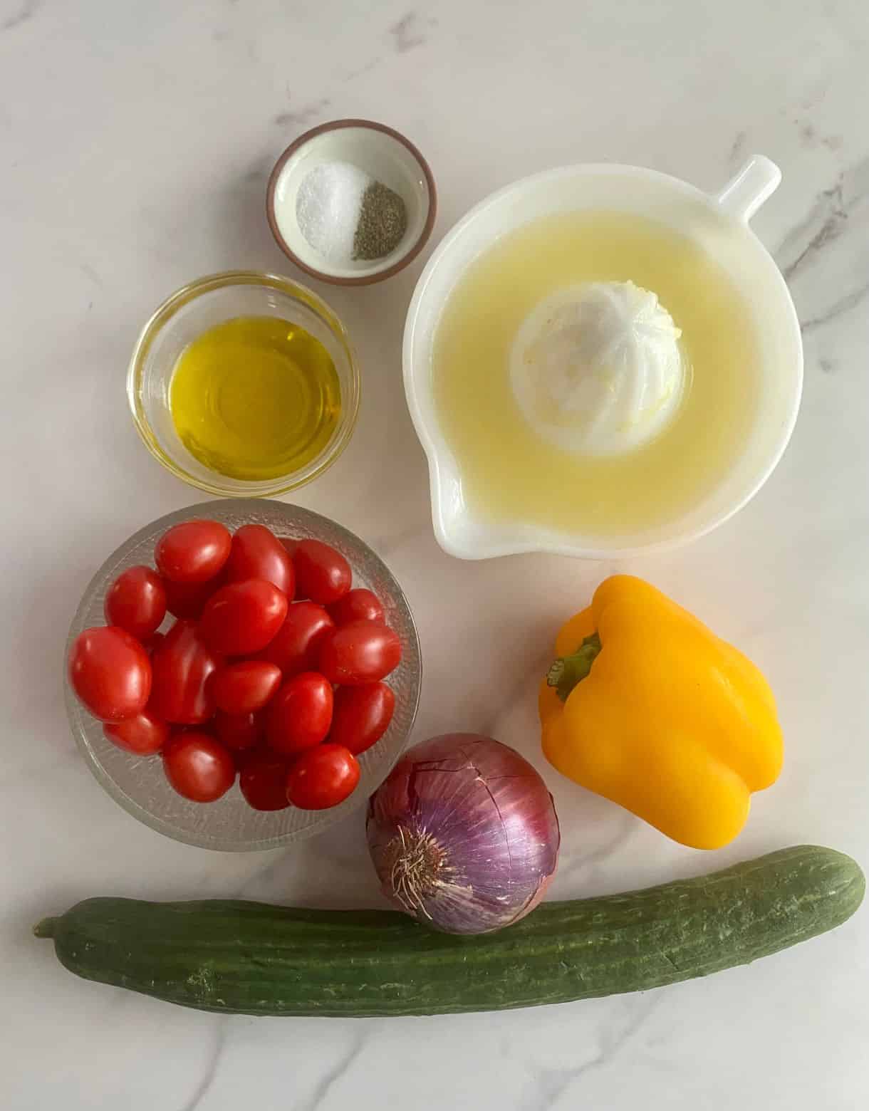 Ingredients for Mediterranean Chopped Salad. A cucumber, red onion, bell pepper, grape tomatoes, lemon juice, olive oil, salt and pepper.