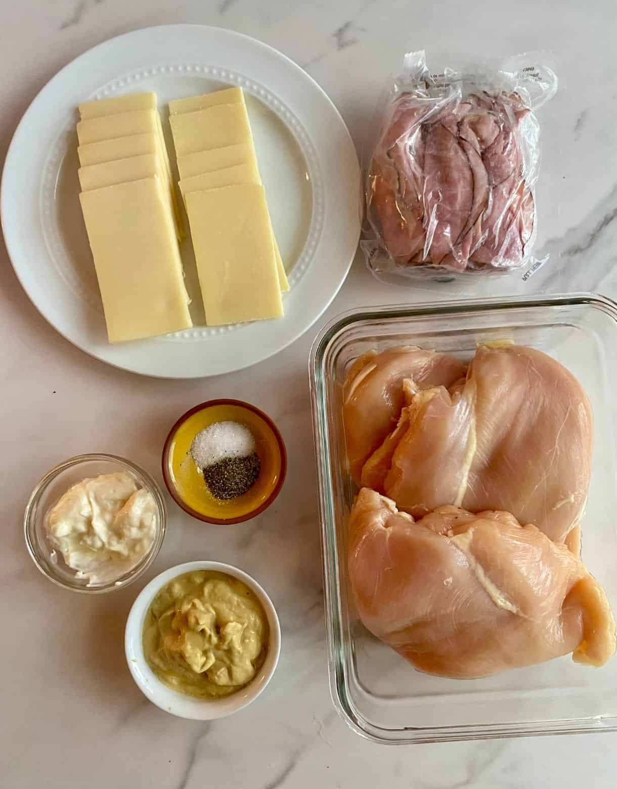 Ingredients for Healhty Chicken Cordon Bleu. Raw chicken breasts, sliced ham, sliced swiss cheese, salt, pepper, mayonnaise and Dijon mustard.