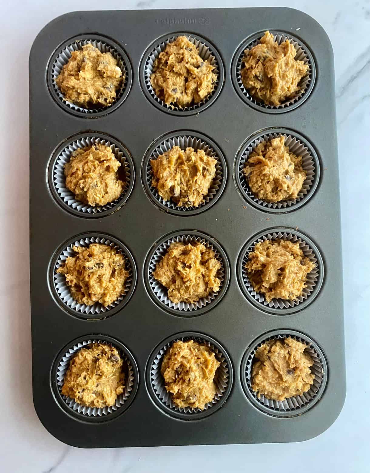 A pan of unbaked muffins ready to go in the oven.