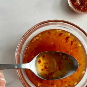 A bowl of Sweet Chili Sauce with a spoon.