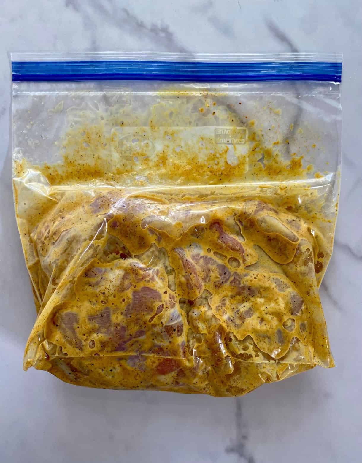 A freezer bag with marinating Garam Masala Chicken Thighs.