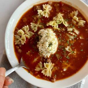A bowl of Healthy Lasagna Soup with a dollop of cheese.