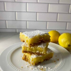A stack of 3 lemon bars with a graham cracker crust.