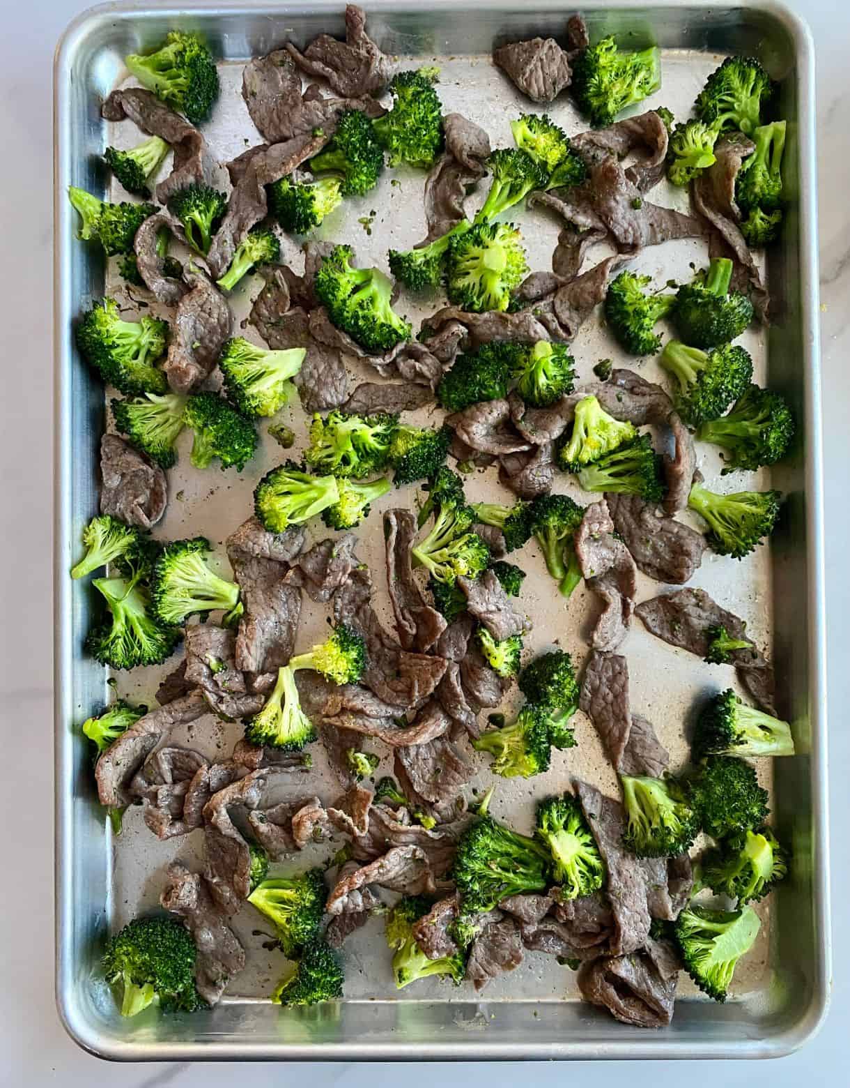 Cooked beef and broccoli on a sheet pan.