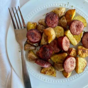 A plate of oven roasted smoked sausage and potatoes.