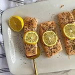 A platter with cooked Baked Salmon with Dill and Lemon.