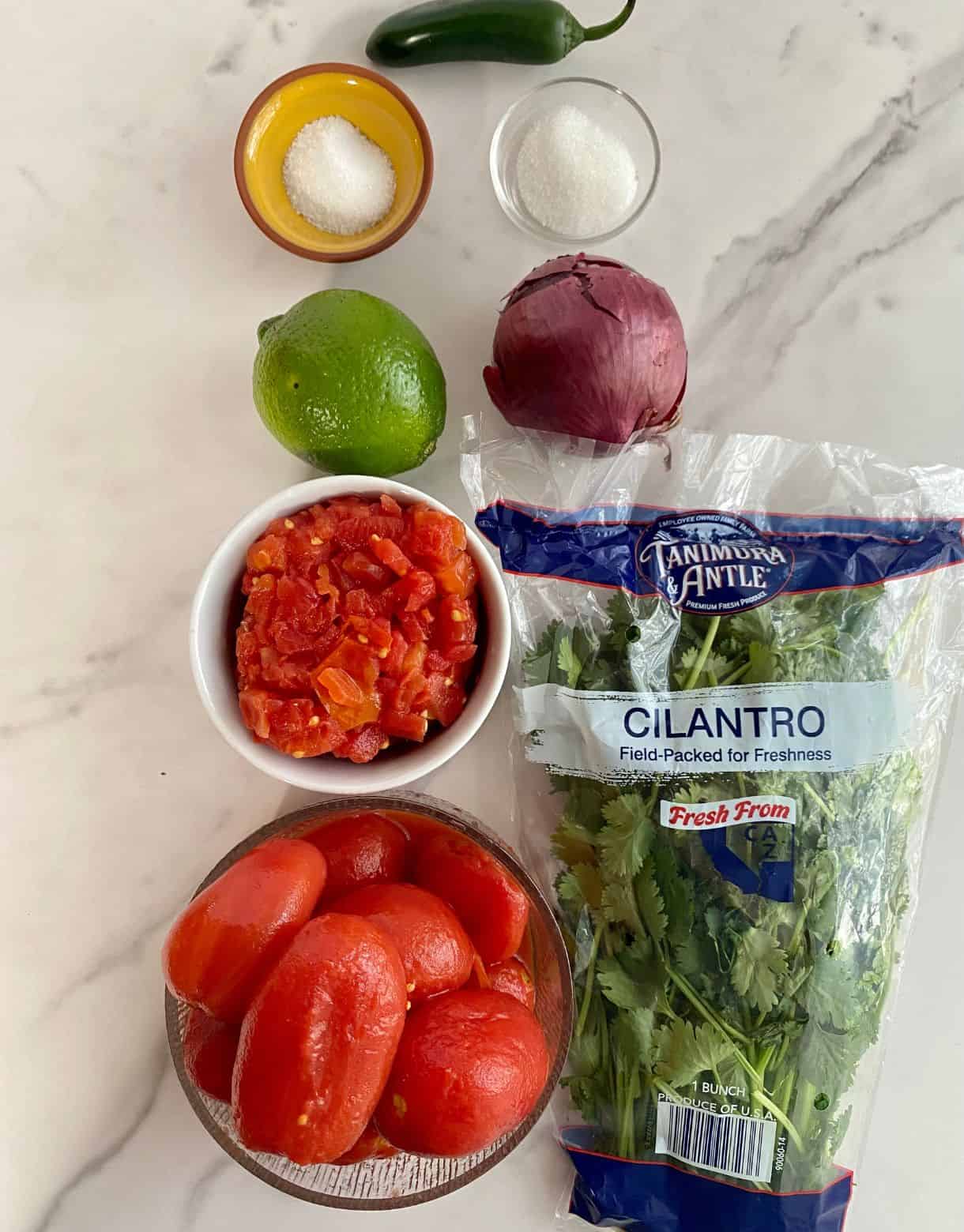 Ingredients for Jalapeno Salsa. A jalapeno, salt, sugar, lime, red onion, canned diced tomatoes with chiles, canned whole tomatoes and cilantro.