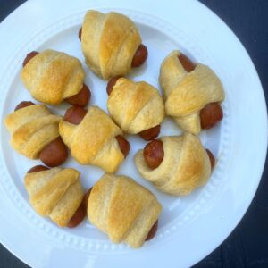A plate of cooked Little Smokies Pigs in a Blanket.