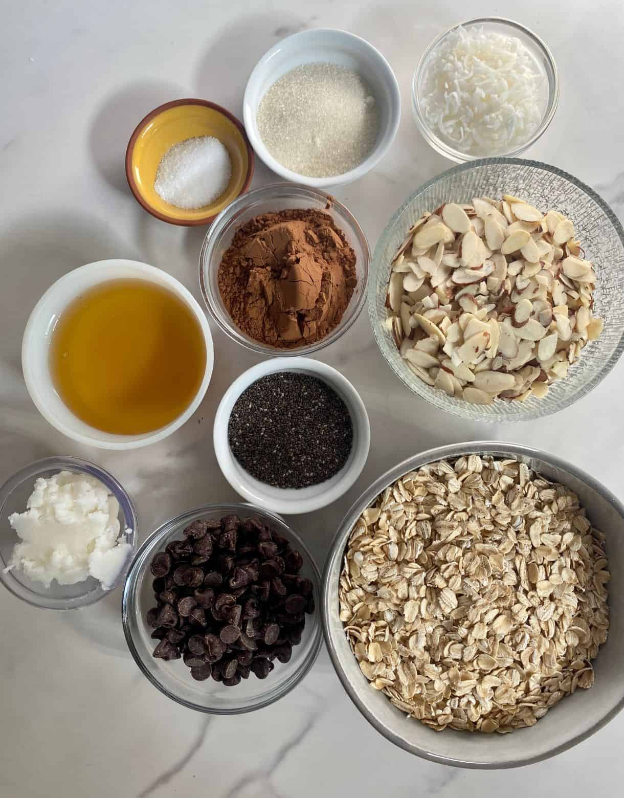 Ingredients for Dark Chocolate Granola. Rolled oats, sliced almonds, chia seeds, shredded coconut, cocoa powder, agave, salt, sugar, coconut oil and chocolate chips.
