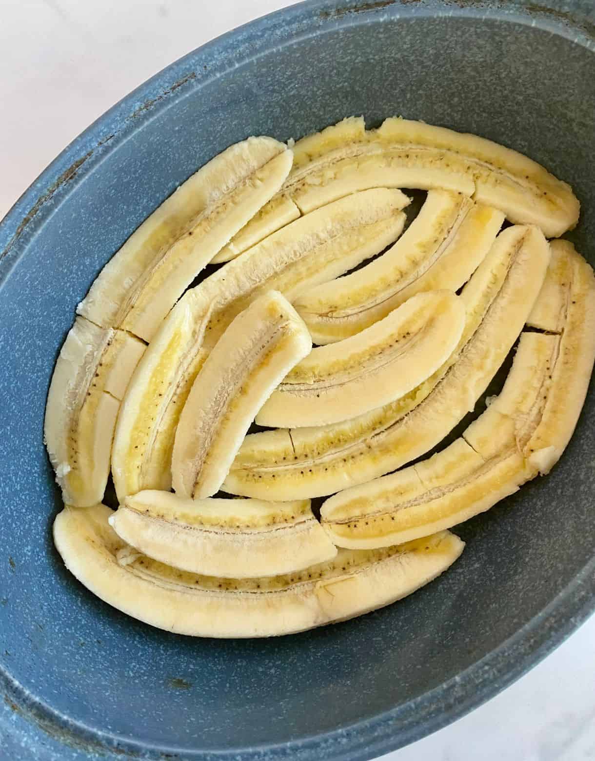 Sliced bananas in a dish ready to bake for Healthy Bananas Foster.
