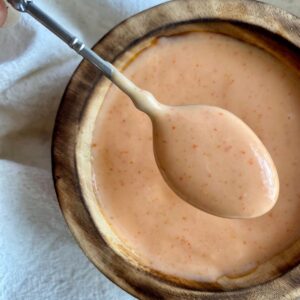 A bowl of Spicy Sriracha Mayo with a spoon.