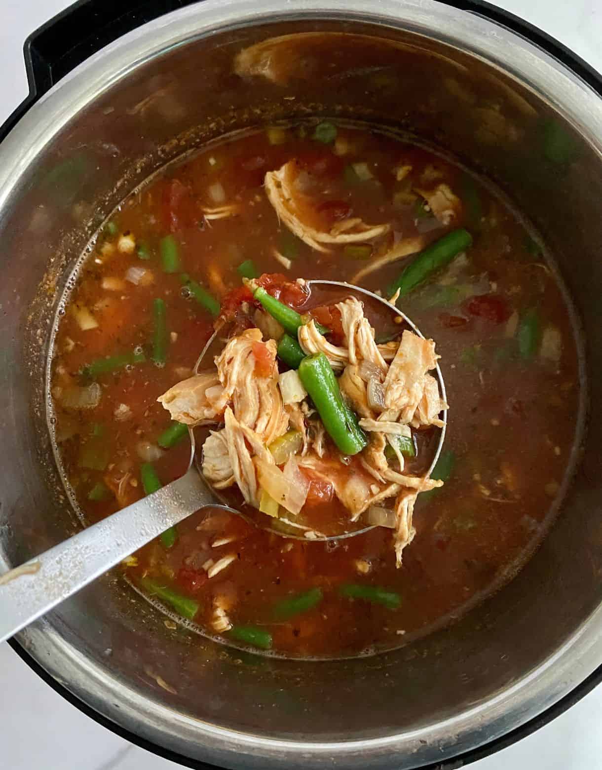 A slow cooker of cooked Chicken Minestrone Soup.
