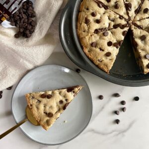 A cooked Deep Dish Cookie Pie with a piece cut out of it.