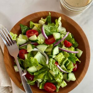 A House Salad with a jar of Red Wine Vinaigrette.