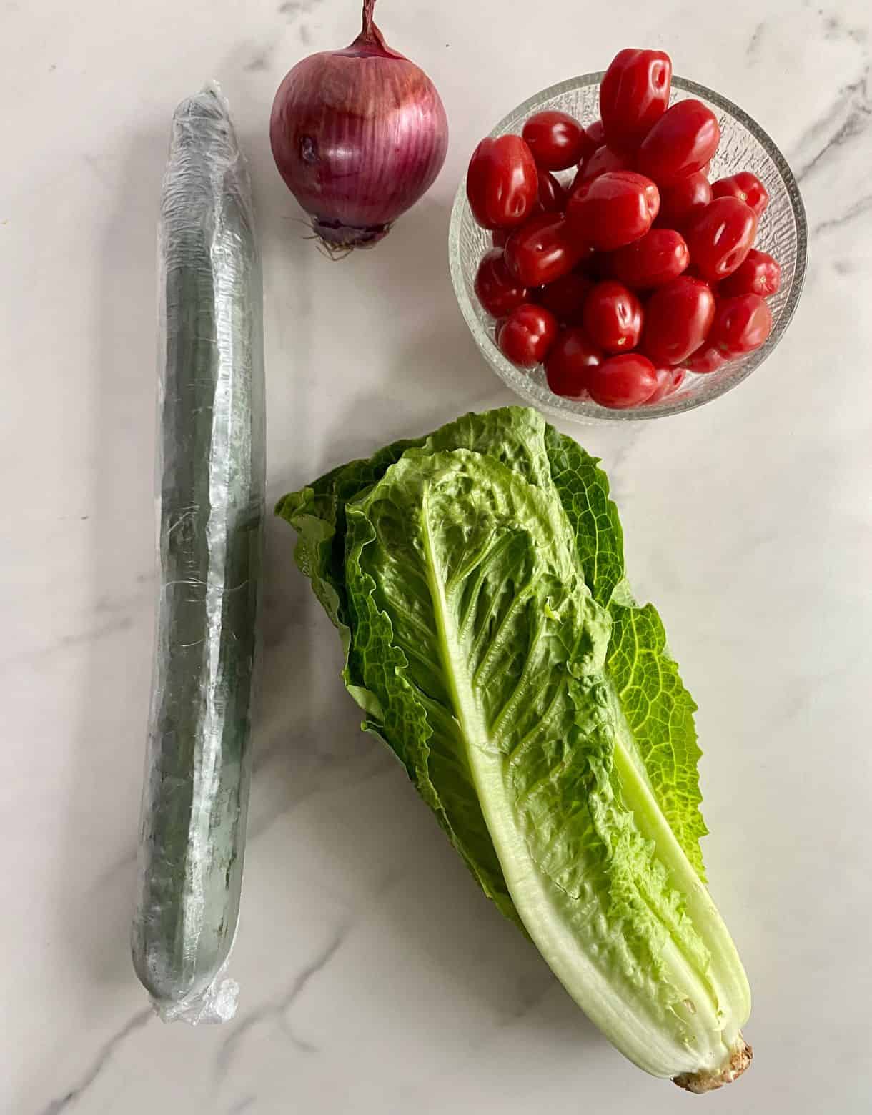 Romaine lettuce, a cucumber, a red onion and grape tomatoes.
