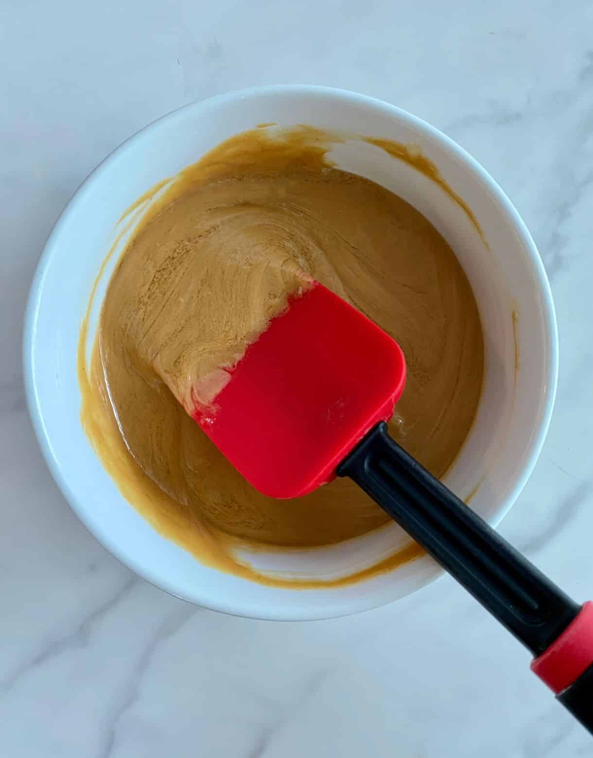 A bowl with melted honey and peanut butter.