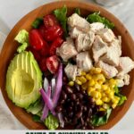 A Santa Fe Chicken Salad in a wooden bowl with a dish of Creamy Salsa Dressing.