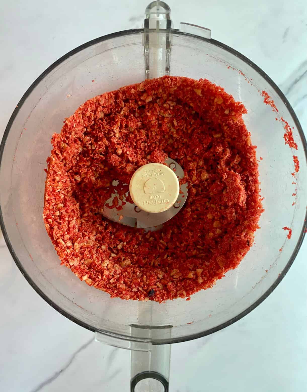 A food processor with crushed Takis in it.