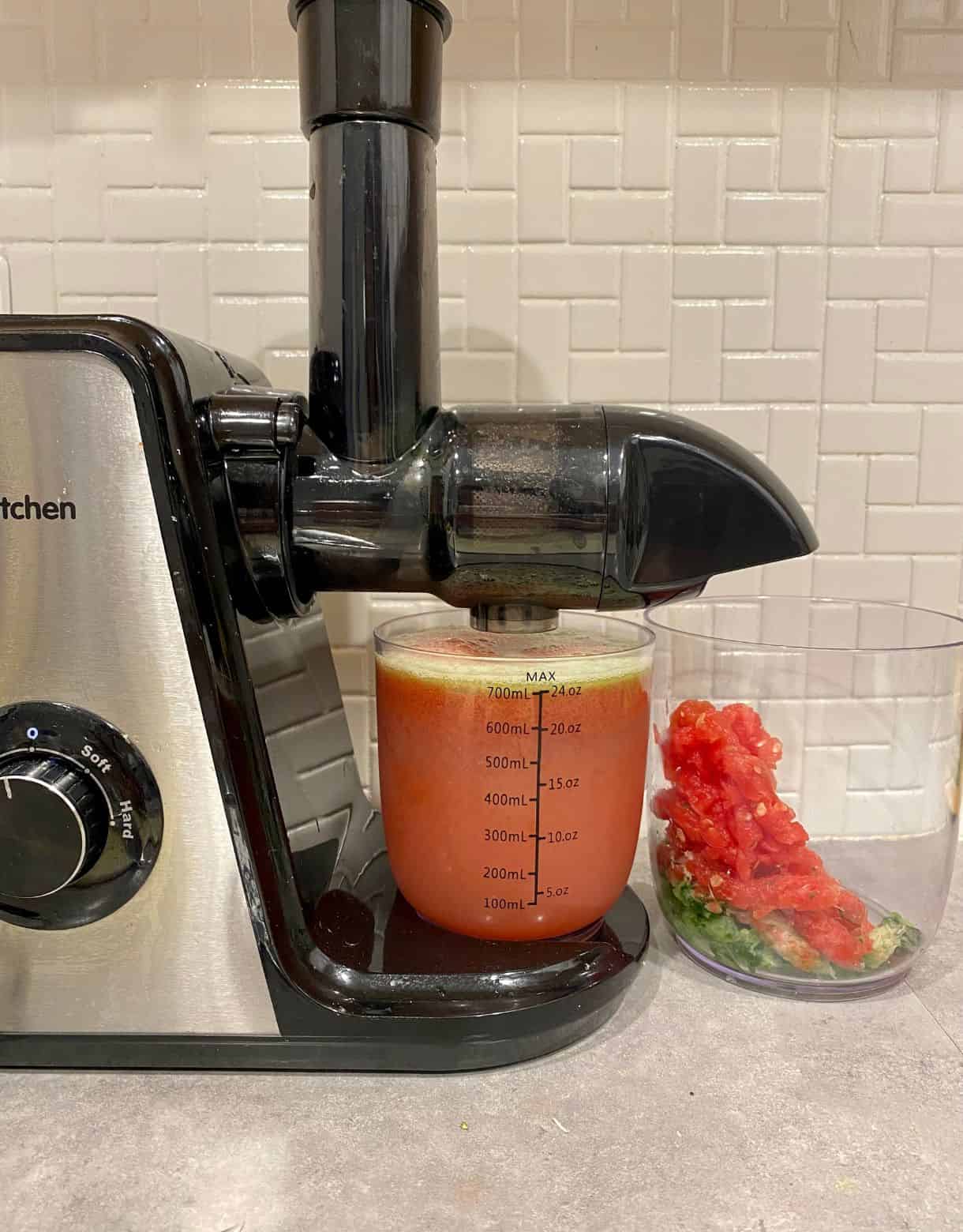 A juicer with freshly pressed watermelon and cucumber juice.
