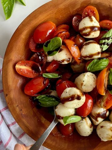 A bowl of Tomato and Bocconcini Salad drizzled with balsamic glaze.