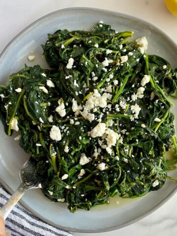 A plate of cooked spinach and feta.